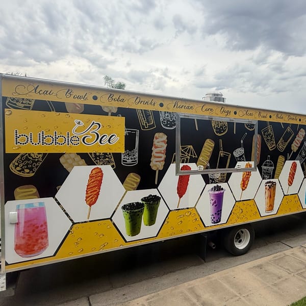 Bubble Bee food truck with colorful images of boba drinks and Korean corn dogs on its side.