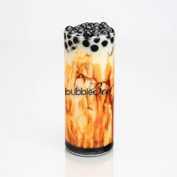 Bubble Bee's brown sugar boba milk tea with dark pearls and caramel swirls in a tall glass.