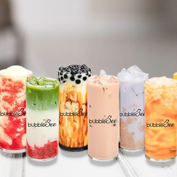 Six vibrant BubbleBee bubble tea drinks in tall glasses, featuring various colors and toppings.