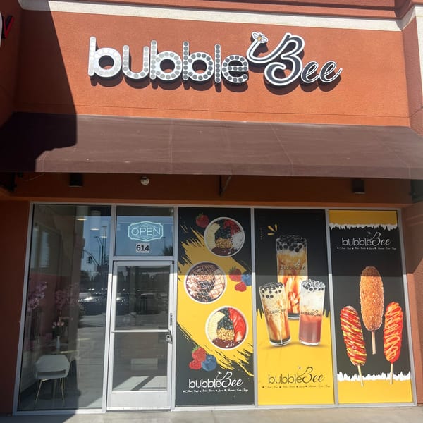The Bubble Bee storefront with a large sign and window decals showing acai bowls, bubble tea, and corn dogs.